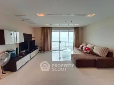 Spacious living room with modern entertainment setup and ocean view balcony.