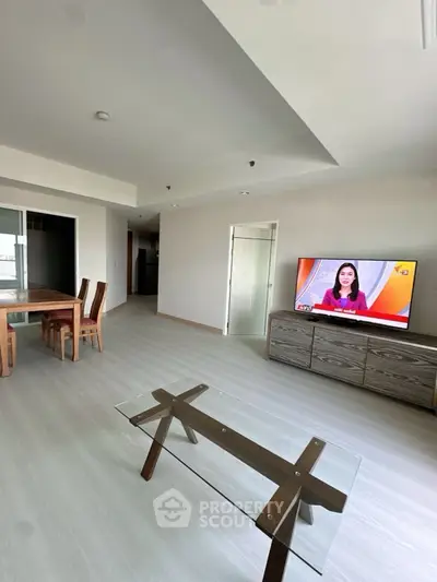 Spacious living room with modern furniture and TV, perfect for relaxation.