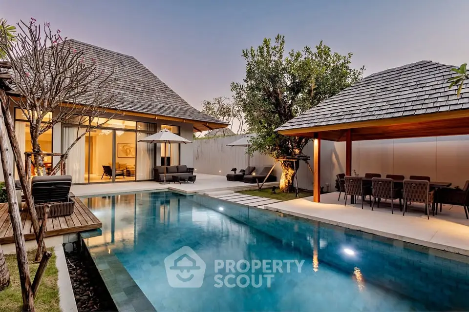 Luxurious villa with private pool and outdoor dining area at sunset, perfect for relaxation and entertainment.