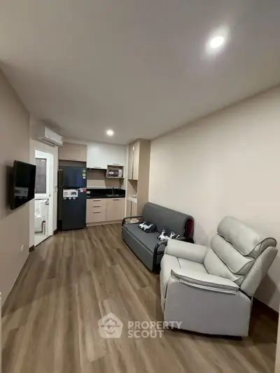 Modern living room with sleek kitchen and cozy seating area, perfect for urban living.