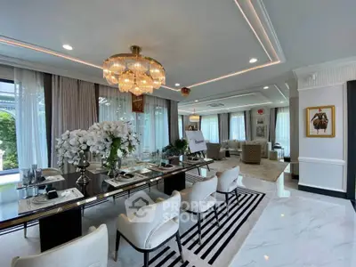 Luxurious living room with elegant dining area, modern decor, and large windows offering natural light.