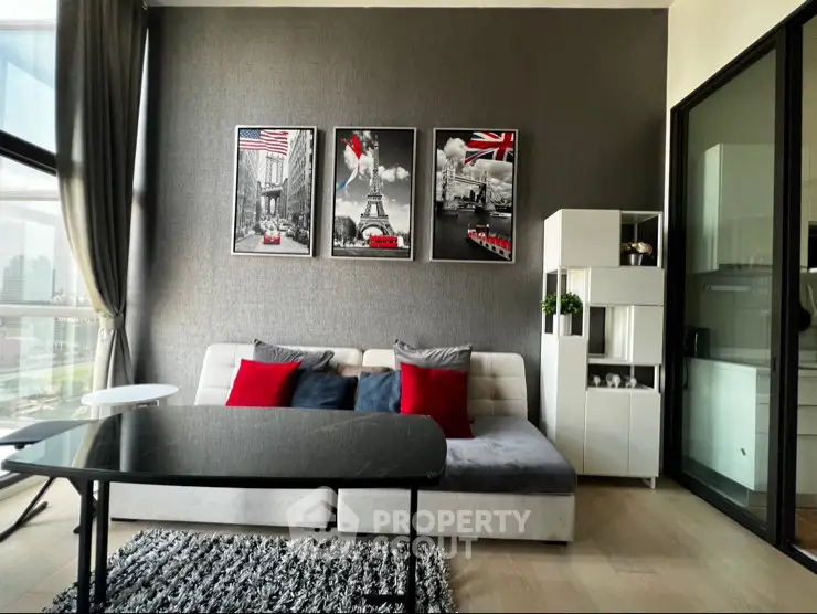 Modern living room with stylish decor and city view, featuring a cozy sofa and elegant wall art.