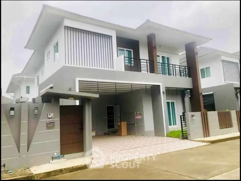 Modern two-story house with sleek design and spacious driveway in a suburban neighborhood.
