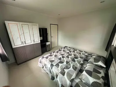 Spacious bedroom with modern decor and ample natural light.