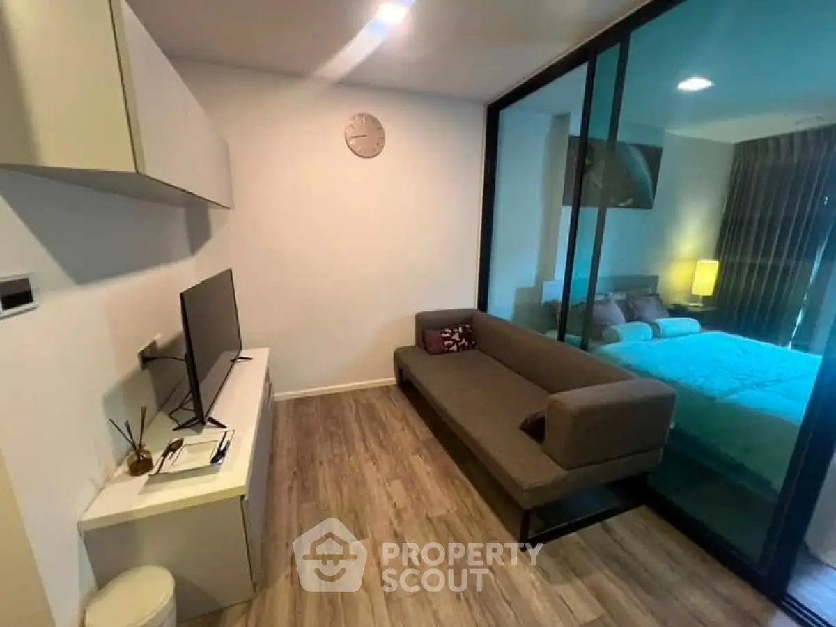 Modern living room with sleek design and cozy ambiance, featuring a stylish sofa and wall-mounted TV.