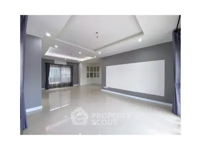 Spacious modern living room with elegant ceiling design and large windows.