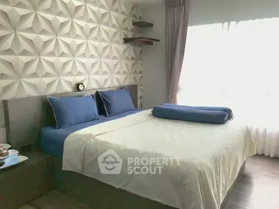Modern bedroom with stylish geometric wall design and cozy bedding