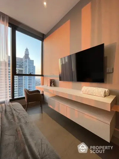 Modern bedroom with city view, featuring wall-mounted TV and stylish furniture.