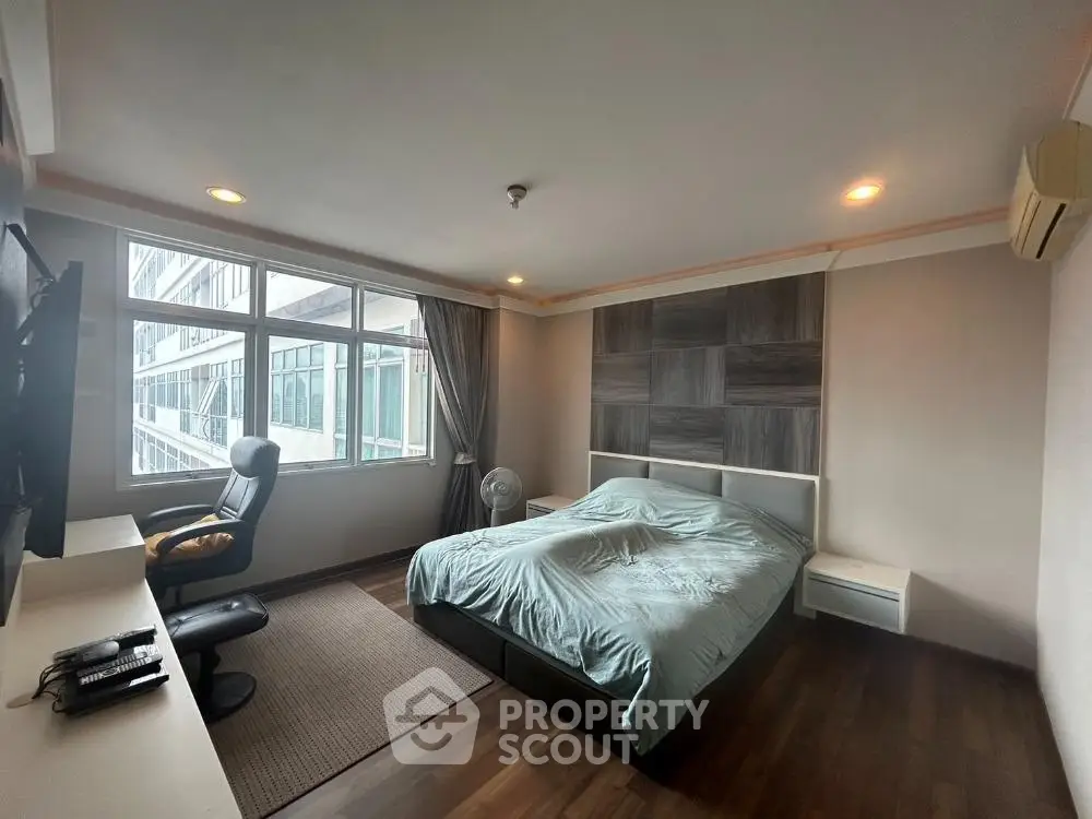 Spacious bedroom with modern decor and large window view