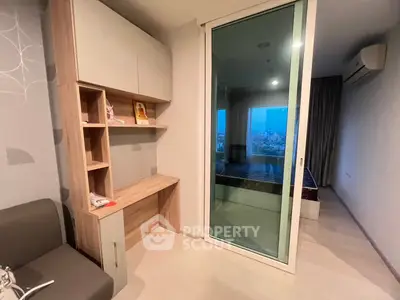 Modern apartment interior with sliding glass door leading to a cozy bedroom and city view.