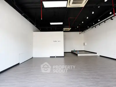 Spacious commercial interior with modern flooring and high ceilings, ideal for retail or office space.