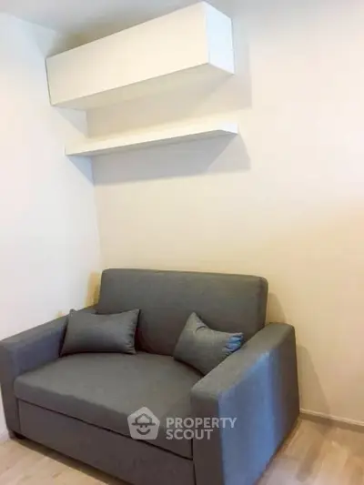 Cozy living room with modern gray sofa and minimalist shelving