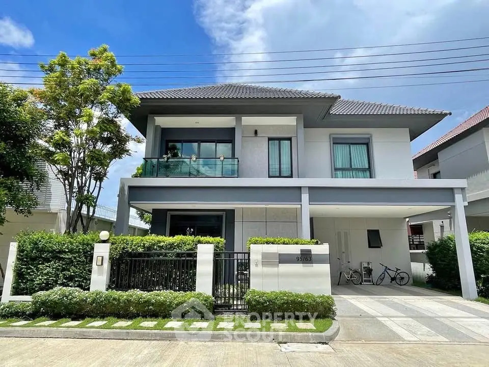 Modern two-story house with balcony and garage in a serene neighborhood