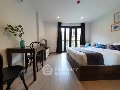Modern bedroom with stylish decor and large windows offering natural light
