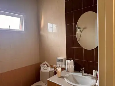 Modern bathroom with oval mirror and natural light
