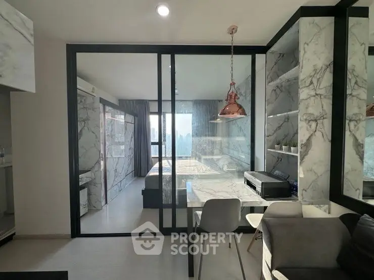 Modern apartment with marble decor and glass partition in stylish living area.
