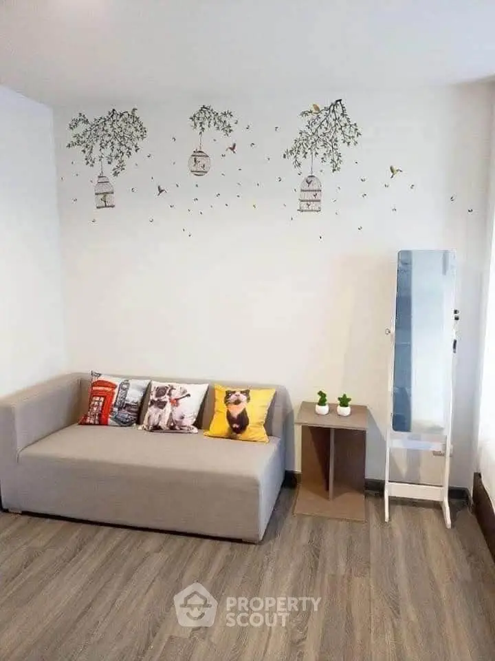 Charming living room with cozy sofa, decorative pillows, and elegant wall art, perfect for relaxation.