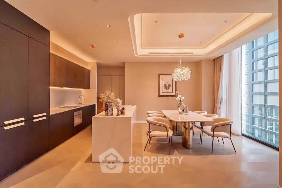 Luxurious modern kitchen and dining area with elegant lighting and large windows.
