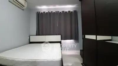 Modern bedroom with minimalist design, featuring a comfortable bed and sleek wardrobe.