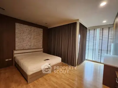 Spacious bedroom with modern design and large windows for natural light.