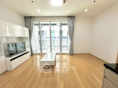 Spacious modern living room with large windows and wooden flooring