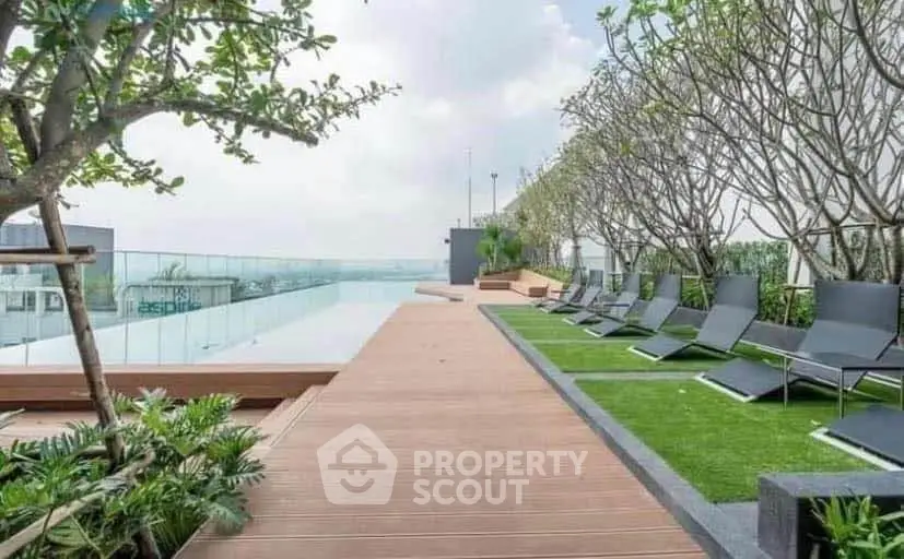 Luxurious rooftop pool area with modern lounge chairs and lush greenery, offering a serene escape in the city.
