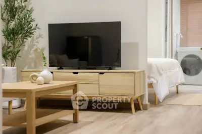 Modern living room with stylish wooden furniture and TV, adjacent to a cozy bedroom.