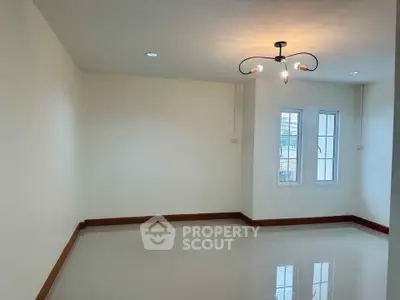 Spacious unfurnished room with modern lighting and large window, perfect for customization.