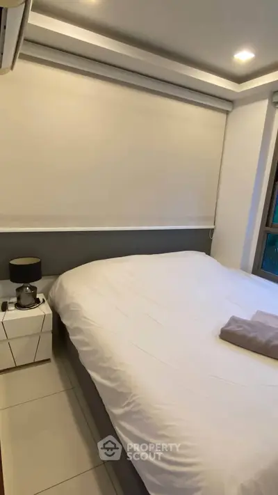 Cozy bedroom with modern decor and ambient lighting, featuring a comfortable bed and stylish nightstand.