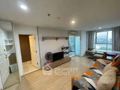 Modern living room with balcony and city view, featuring stylish decor and ample natural light.