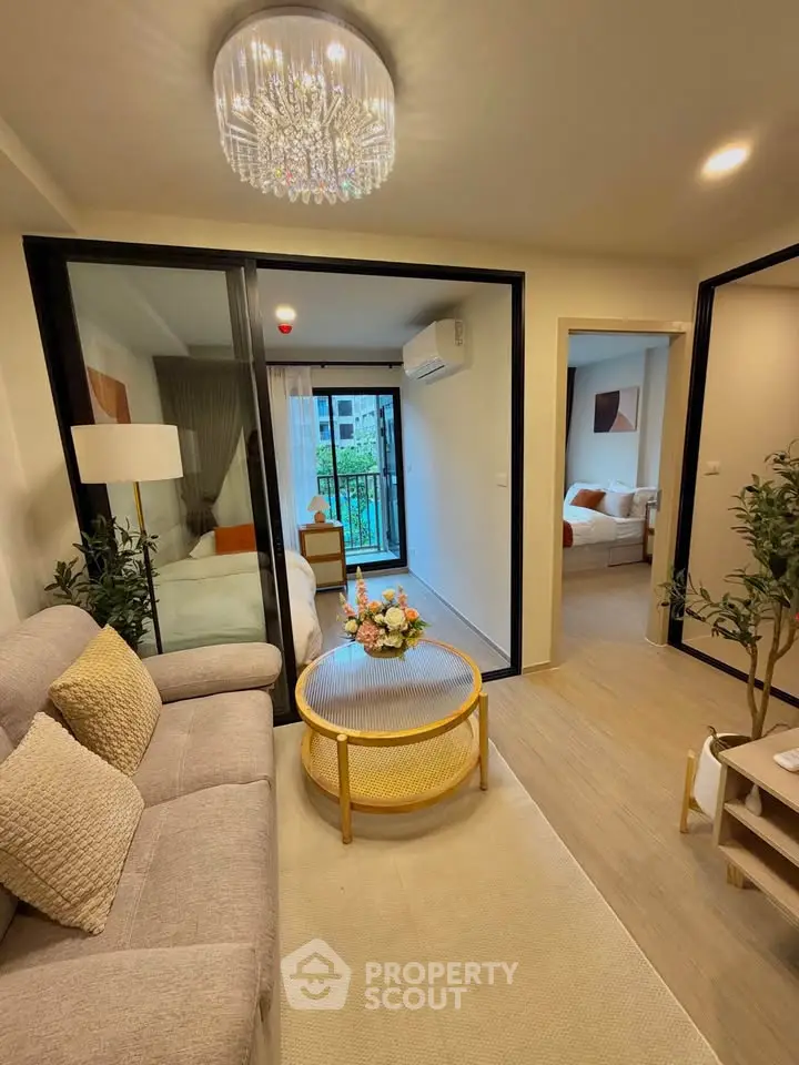 Modern living room with elegant decor and glass partition, featuring cozy seating and stylish lighting.