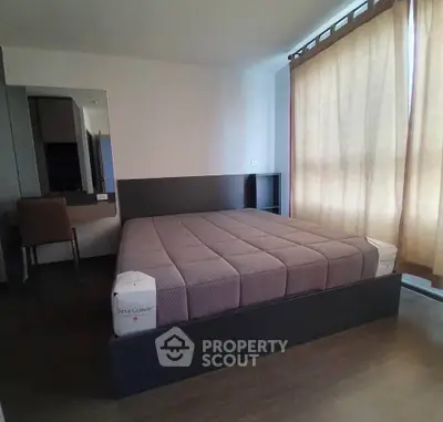 Modern bedroom with large window and stylish furniture in a contemporary apartment.