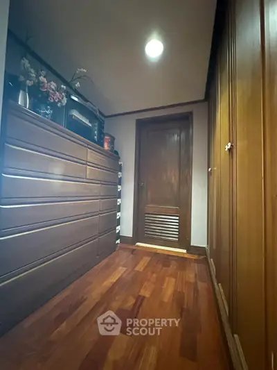 Spacious storage room with wooden flooring and ample cabinetry