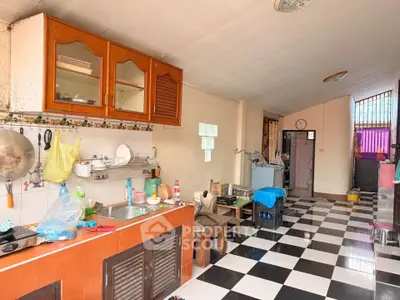 Spacious kitchen with checkered floor and ample storage in a cozy home.