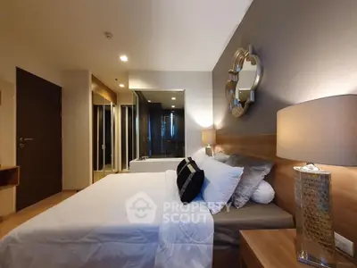 Luxurious bedroom with modern decor and ensuite bathroom in upscale apartment