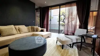 Luxurious living room with modern furniture and large windows opening to a serene balcony view.