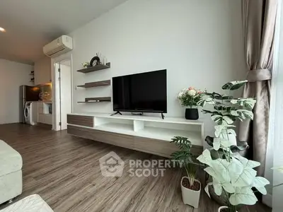 Modern living room with sleek TV unit and stylish decor, featuring wood flooring and natural light.