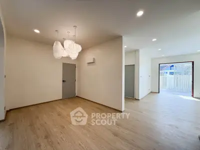 Spacious modern living room with elegant lighting and wooden flooring, perfect for family gatherings.
