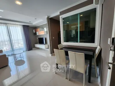 Modern living room with sleek furniture and large windows offering city views.