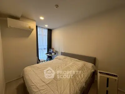 Cozy bedroom with modern air conditioning and natural light from large window.