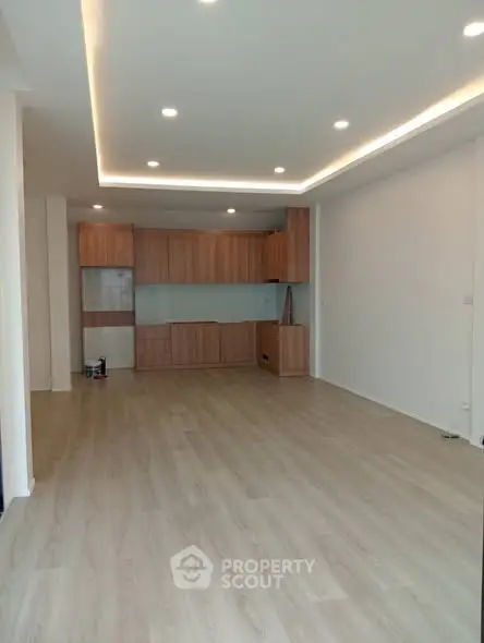 Spacious modern living room with wooden flooring and built-in cabinets