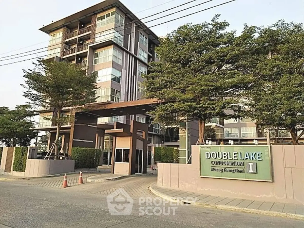 Modern condominium building with lush greenery and welcoming entrance.