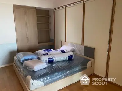 Spacious bedroom with wooden flooring and modern bed setup