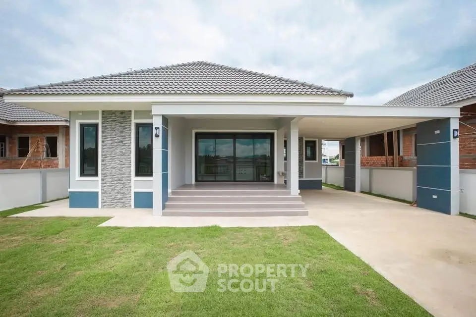 Modern single-story house with spacious driveway and manicured lawn
