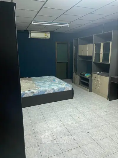 Spacious bedroom with modern shelving and air conditioning, ideal for comfortable living.