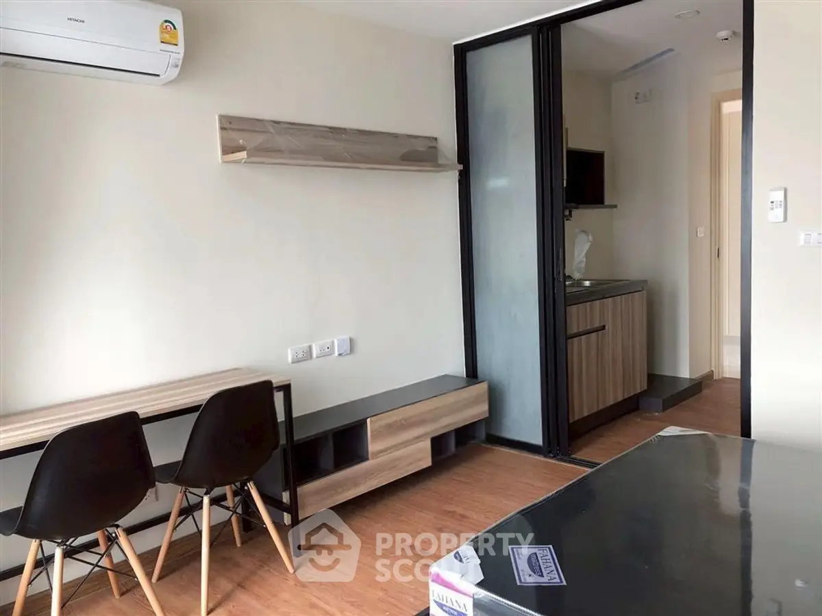 Modern studio apartment with compact kitchen and stylish furnishings, perfect for urban living.