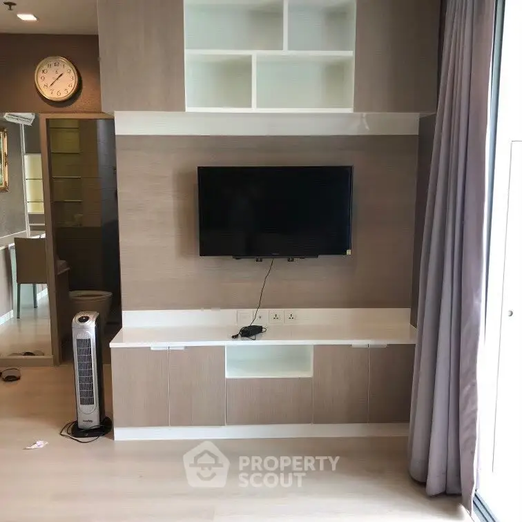 Modern living room with wall-mounted TV and stylish cabinetry
