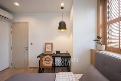 Modern bedroom with study area featuring sleek desk and stylish lighting.