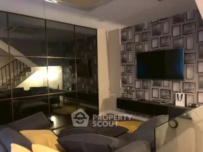 Stylish living room with modern decor and wall-mounted TV, perfect for relaxation and entertainment.