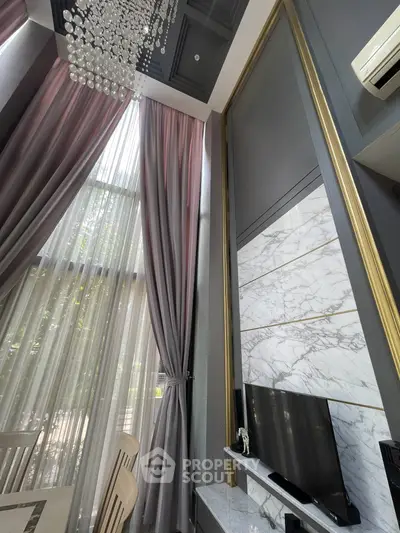 Luxurious high-ceiling living room with elegant chandelier and marble accents